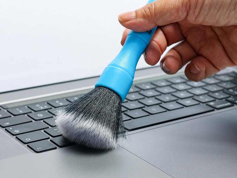 Dépoussiérage d'un clavier avec pinceau