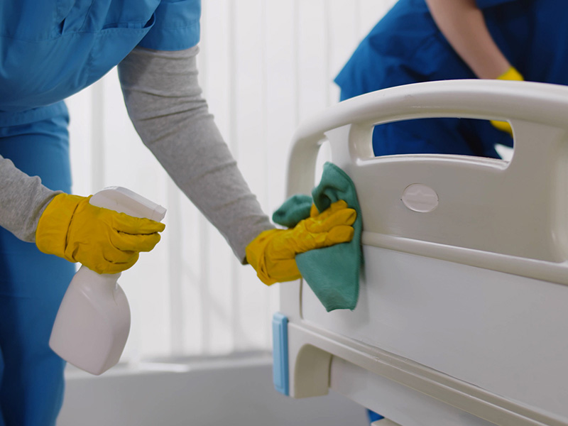Femmes nettoyant un lit d'hôpital