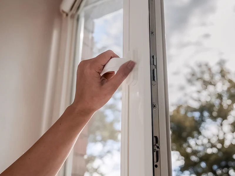 Femme ouvrant une fenêtre pour aérer