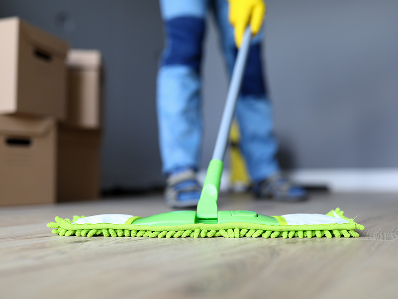 Homme nettoyant le sol avant de quitter son logement